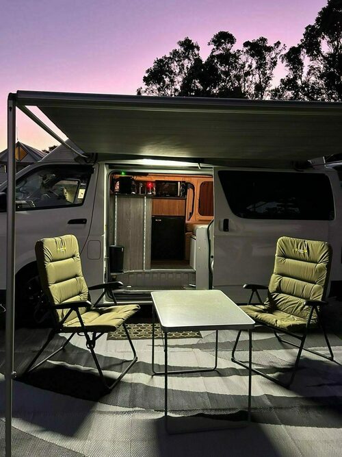 Campervan with the awning out, table and chairs set up for an evening in the South Island