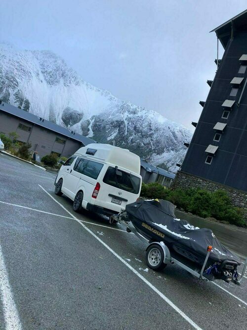 Campervan parked with snow-capped South Island mountains behind