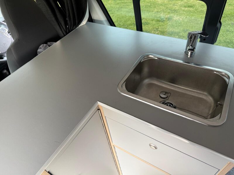 Stainless steel sink and folding tap set into the bench inside Harriet
