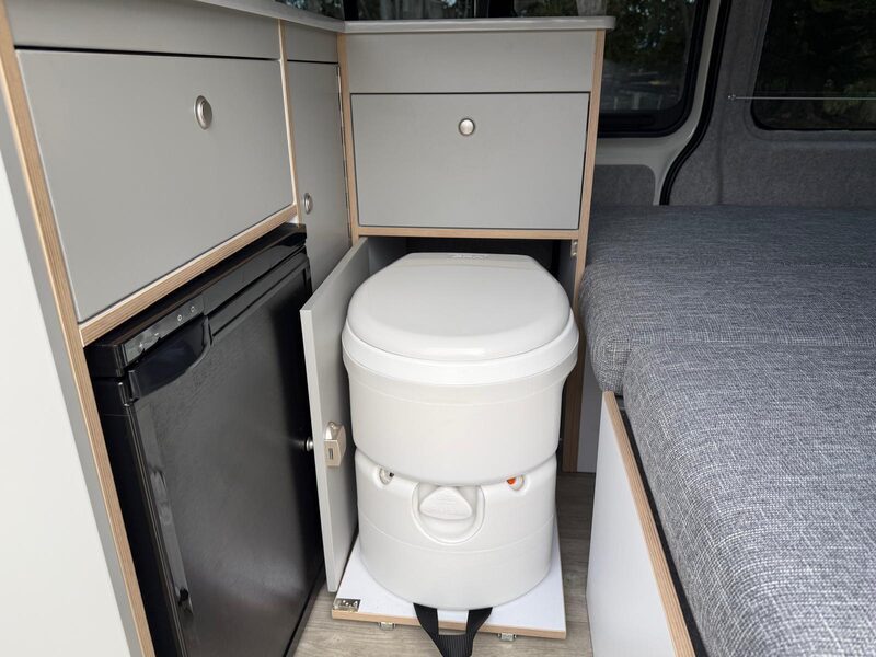 The toilet stowed beside the fridge inside Harriet